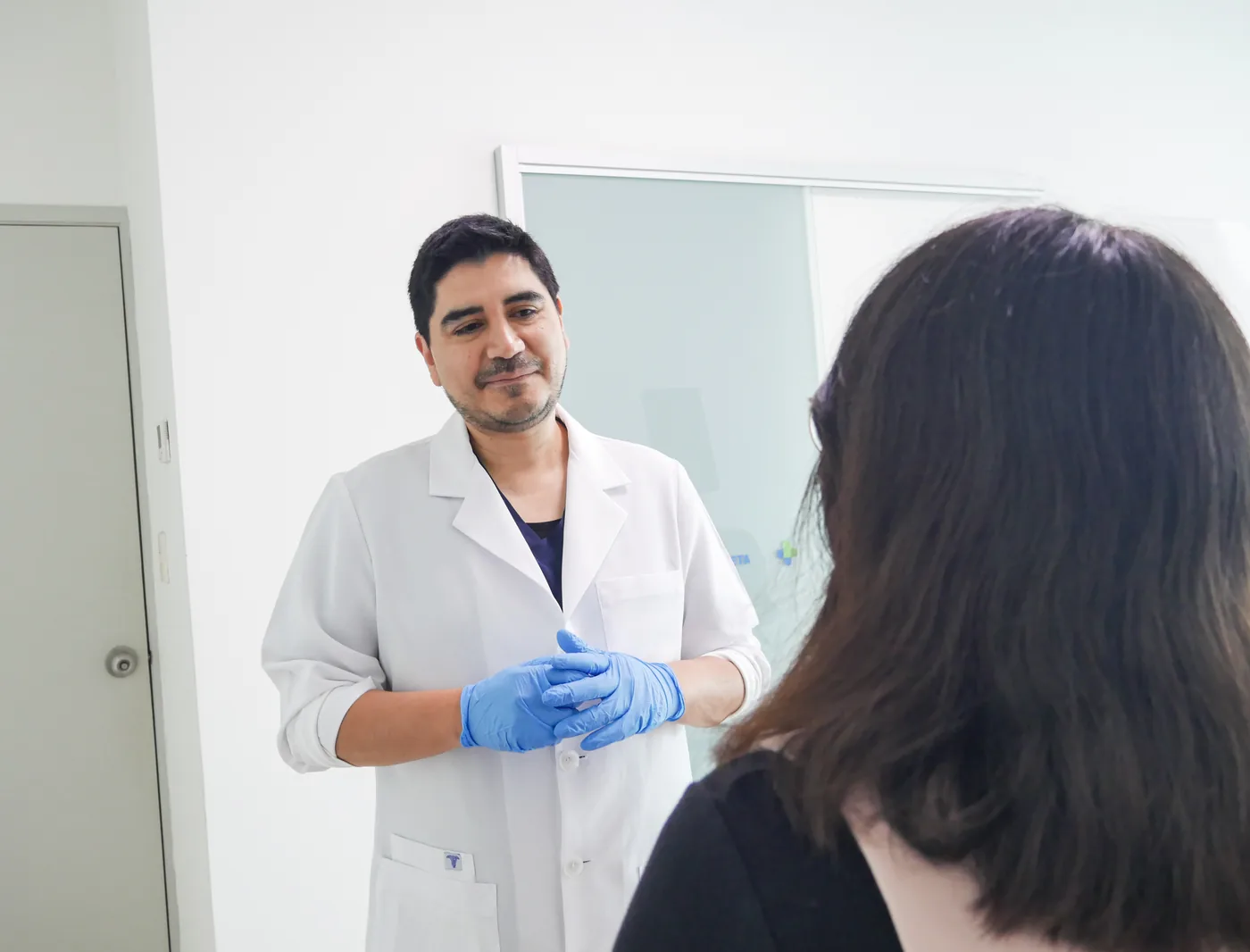 Dr. Luis Schwarz conversando de pie con el paciente sobre el plan de seguimiento